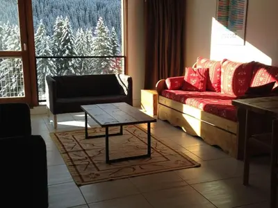 a living room with a couch and a table in front of a window at Appartement 3 pièces rénové, 8 pers, proche pistes, Wifi - FR-1-687-23 in Arâches-la-Frasse