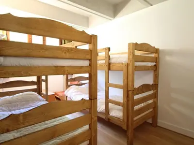 a room with three bunk beds in a room at Appartement 3 pièces rénové, 8 pers, proche pistes, Wifi - FR-1-687-23 in Arâches-la-Frasse