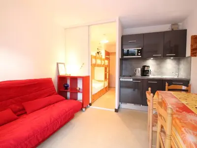 a living room with a red couch and a kitchen at Studio rénové à Flaine Forêt, résidence Sirius, à 500m des pistes – 5 couchages - FR-1-687-17 in Arâches-la-Frasse