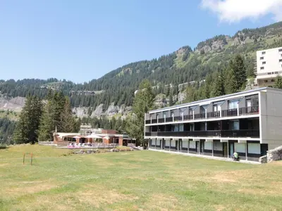 a building with a large field in front of a mountain at Studio pour 4 pers à Flaine, au pied des pistes - FR-1-687-60 in Arâches-la-Frasse