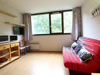 a living room with a red couch in front of a window at Studio 4 pers, lave-vaisselle, proche pistes et commerces, navette gratuite - FR-1-687-47 in Arâches-la-Frasse