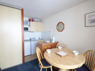 a kitchen with a table and chairs and a kitchen with a refrigerator at Studio Cabine 5 pers avec Balcon - Résidence Sagittaire, Flaine Forêt - FR-1-687-43 in Arâches-la-Frasse