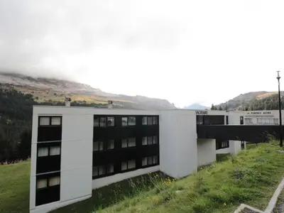 a building in a field with a mountain in the background at Studio Cabine 5 pers avec Balcon - Résidence Sagittaire, Flaine Forêt - FR-1-687-43 in Arâches-la-Frasse