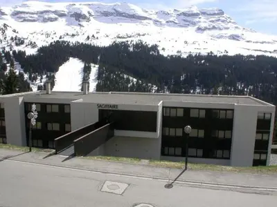 a building with a snow covered mountain in the background at Studio Cabine 5 pers avec Balcon - Résidence Sagittaire, Flaine Forêt - FR-1-687-43 in Arâches-la-Frasse