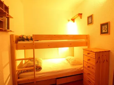 a bedroom with a bunk bed and a dresser at Appartement rénové 2 pièces pour 6 personnes avec balcon sud à 300m des pistes - Flaine Forêt - FR-1-687-48 in Arâches-la-Frasse