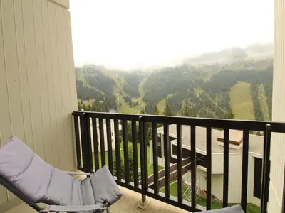 a balcony with a chair and a view of a valley at Appartement rénové 2 pièces pour 6 personnes avec balcon sud à 300m des pistes - Flaine Forêt - FR-1-687-48 in Arâches-la-Frasse