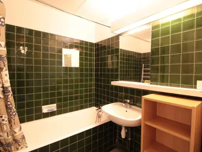 a green tiled bathroom with a sink and a mirror at Appartement 3 pièces pour 8 pers, au pied des pistes – Résidence Aldebaran, Flaine Forum - FR-1-687-57 in Arâches-la-Frasse
