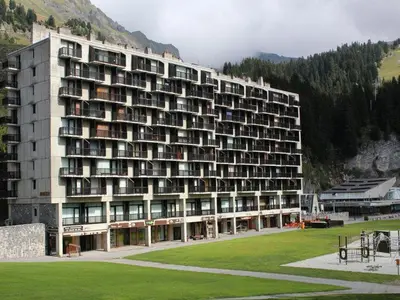 a large building with a grass field in front of it at Appartement 3 pièces pour 8 pers, au pied des pistes – Résidence Aldebaran, Flaine Forum - FR-1-687-57 in Arâches-la-Frasse