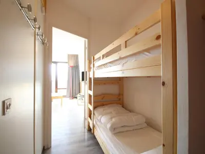 a bedroom with two bunk beds and a hallway at Studio rénové 4 pers avec balcon sud, proche pistes et commerces, casier à skis, parking - FR-1-687-33 in Arâches-la-Frasse