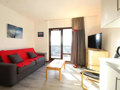 a living room with a red couch and a television at Studio rénové 4 pers avec balcon sud, proche pistes et commerces, casier à skis, parking - FR-1-687-33 in Arâches-la-Frasse