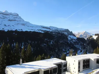 a building with a mountain in the background at Studio rénové 4 pers avec balcon sud, proche pistes et commerces, casier à skis, parking - FR-1-687-33 in Arâches-la-Frasse