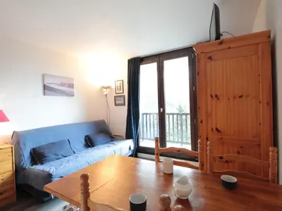 a living room with a blue couch and a table at Studio lumineux avec balcon et vue sur pistes, animaux admis - FR-1-687-61 in Arâches-la-Frasse