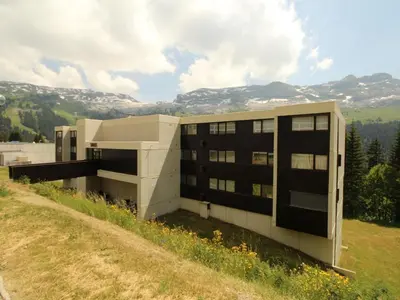 a building on top of a hill with a field at Studio lumineux avec balcon et vue sur pistes, animaux admis - FR-1-687-61 in Arâches-la-Frasse