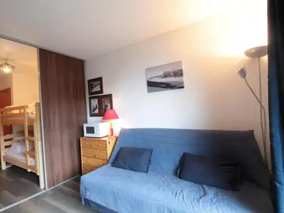 a living room with a blue couch in a room at Studio lumineux avec balcon et vue sur pistes, animaux admis - FR-1-687-61 in Arâches-la-Frasse