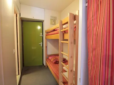 a room with bunk beds and a green door at Studio Coin Montagne 25m² à Flaine, balcon et proximité pistes - FR-1-687-42 in Arâches-la-Frasse