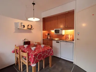 a kitchen with a table with a red table cloth at Studio Coin Montagne 25m² à Flaine, balcon et proximité pistes - FR-1-687-42 in Arâches-la-Frasse
