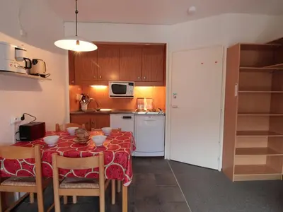 a kitchen with a table with chairs and a kitchen with a kitchen at Studio Coin Montagne 25m² à Flaine, balcon et proximité pistes - FR-1-687-42 in Arâches-la-Frasse