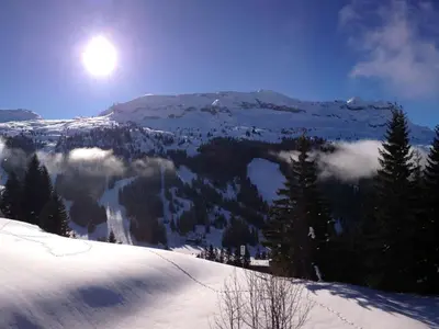 a snow covered mountain with the sun in the sky at Studio pour 4 pers., proche pistes et commerces, balcon sud, à Flaine Forêt - FR-1-687-66 in Arâches-la-Frasse