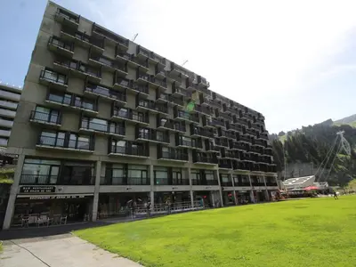 a large building with a grass field in front of it at Appartement 2 Pièces pour 6 Personnes au Pied des Pistes – Flaine Forum, Résidence Aldebarran - FR-1-687-99 in Arâches-la-Frasse