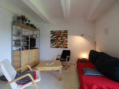 a living room with a red couch and a table at Appartement 2 Pièces pour 6 Personnes au Pied des Pistes – Flaine Forum, Résidence Aldebarran - FR-1-687-99 in Arâches-la-Frasse