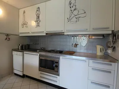 a kitchen with white cabinets with drawings on the wall at Appartement 2 Pièces pour 6 Personnes au Pied des Pistes – Flaine Forum, Résidence Aldebarran - FR-1-687-99 in Arâches-la-Frasse