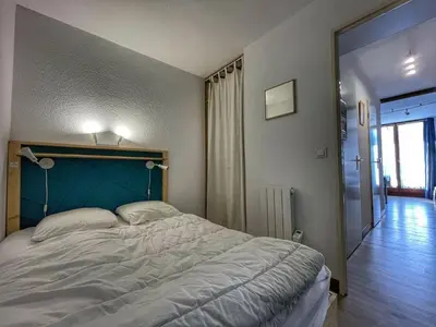 a bedroom with a large bed with a blue headboard at Charmant Studio Cabine avec Coin Montagne pour 5 Pers., Résidence Doris, Proche Pistes et Commerces. - FR-1-687-62 in Arâches-la-Frasse