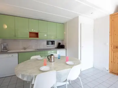 a kitchen with a table with white chairs and green cabinets at Appartement 2 pièces pour 6 personnes, au pied des pistes – Résidence Aldebaran, Flaine Forum - FR-1-687-95 in Arâches-la-Frasse
