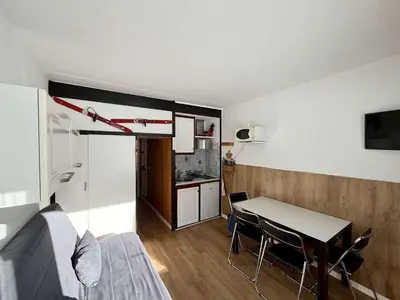 a living room with a table and a kitchen at Studio 4 pers. sur les pistes à Flaine, parking, casier à skis, terrasse - FR-1-687-75 in Arâches-la-Frasse