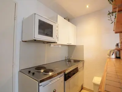 a small kitchen with a stove and a microwave at Appartement 2 Pièces 6 Pers à Flaine Forêt, Résidence Pollux, Proche Pistes et Commerces - FR-1-687-71 in Arâches-la-Frasse