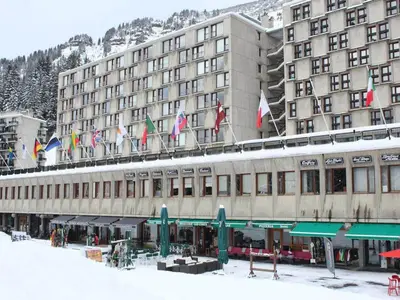a large building with a bunch of flags on it at 2 pièces à Flaine, 6 couchages, à 50m des pistes - FR-1-687-89 in Arâches-la-Frasse
