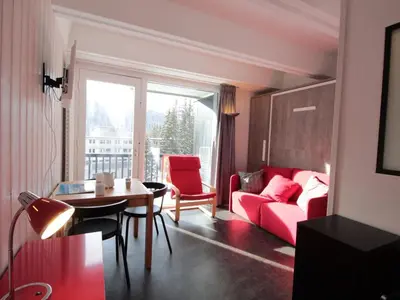 a living room with a red couch and a table at Studio rénové pour 4 pers, balcon, au pied des pistes et commerces - FR-1-687-111 in Arâches-la-Frasse
