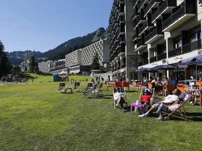 a group of people sitting in lawn chairs in a field at Studio rénové pour 4 pers, balcon, au pied des pistes et commerces - FR-1-687-111 in Arâches-la-Frasse