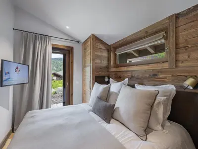 a bedroom with a large bed with wooden walls at Chalet Familial Megève avec Espace Wellness - FR-1-569-56 in Megève