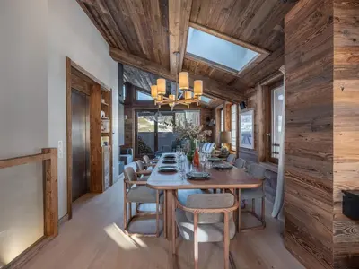 a dining room with a wooden ceiling and a table and chairs at Chalet Familial Megève avec Espace Wellness - FR-1-569-56 in Megève