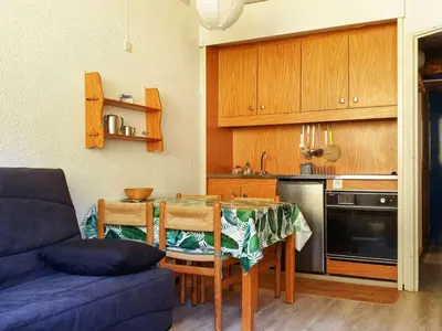 a kitchen with a table and a blue couch at Studio 5 pers à Flaine, proche pistes et commerces, animaux admis - FR-1-687-91 in Arâches-la-Frasse