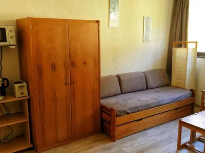 a couch in a room with a large wooden cabinet at Studio 5 pers à Flaine, proche pistes et commerces, animaux admis - FR-1-687-91 in Arâches-la-Frasse