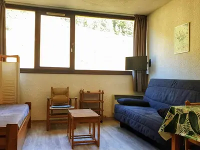 a living room with a blue couch and a chair at Studio 5 pers à Flaine, proche pistes et commerces, animaux admis - FR-1-687-91 in Arâches-la-Frasse