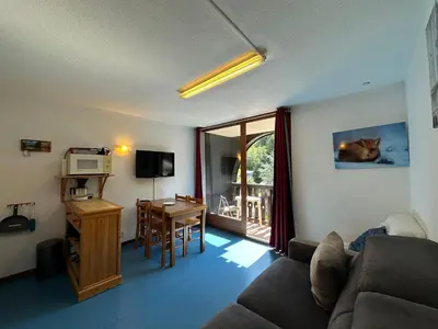 a living room with a couch and a table with a microwave at Studio confortable pour 4 personnes au pied des pistes - FR-1-642-75 in Morillon