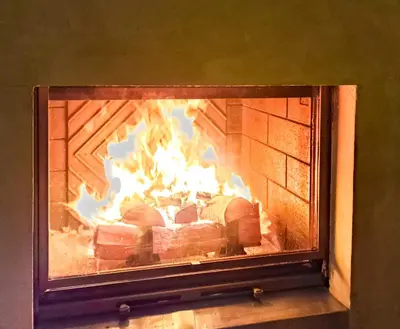 a fireplace with a fire in it at South facing 2-bed apartment with fireplace, Terrasses dEos in Flaine