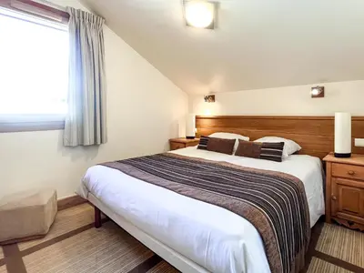 a bedroom with a large bed and a window at South facing 2-bed apartment with fireplace, Terrasses dEos in Flaine