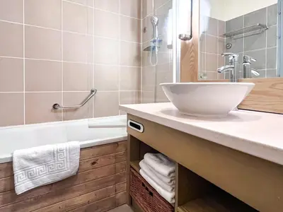 a bathroom with a sink and a bath tub at South facing 2-bed apartment with fireplace, Terrasses dEos in Flaine