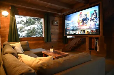 a living room with a couch and a flat screen tv at Chalet Montana in Combloux