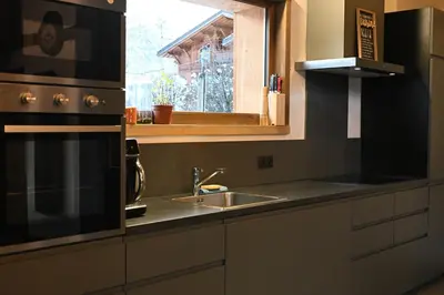 a kitchen with a sink and a stove and a window at Chalet Montana in Combloux