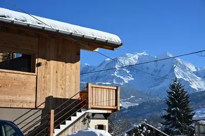 a cabin with a balcony with a snow covered mountain at Chalet Montana in Combloux