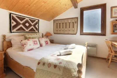 a bedroom with a bed and a table and a window at Les Terrasses de Planpraz - 8min Walk to Center - Quiet - Perfect for Hiking in Chamonix-Mont-Blanc