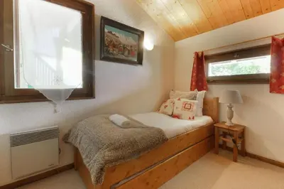 a small bedroom with a bed and a window at Les Terrasses de Planpraz - 8min Walk to Center - Quiet - Perfect for Hiking in Chamonix-Mont-Blanc