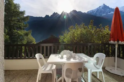 a table and chairs on a balcony with a view at Les Terrasses de Planpraz - 8min Walk to Center - Quiet - Perfect for Hiking in Chamonix-Mont-Blanc