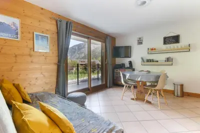 a room with a bed and a table and a balcony at Albertine - Centre de Chamonix - Garage - Mountain Views! in Chamonix-Mont-Blanc