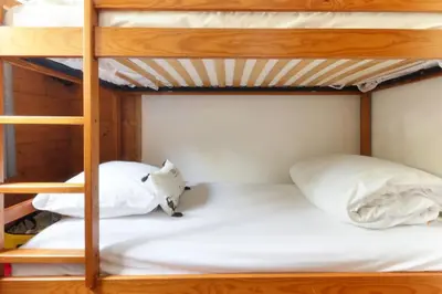 a bunk bed with two white pillows on it at Albertine - Centre de Chamonix - Garage - Mountain Views! in Chamonix-Mont-Blanc