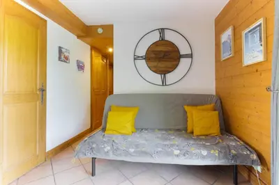 a room with a couch with yellow pillows and a mirror at Albertine - Centre de Chamonix - Garage - Mountain Views! in Chamonix-Mont-Blanc